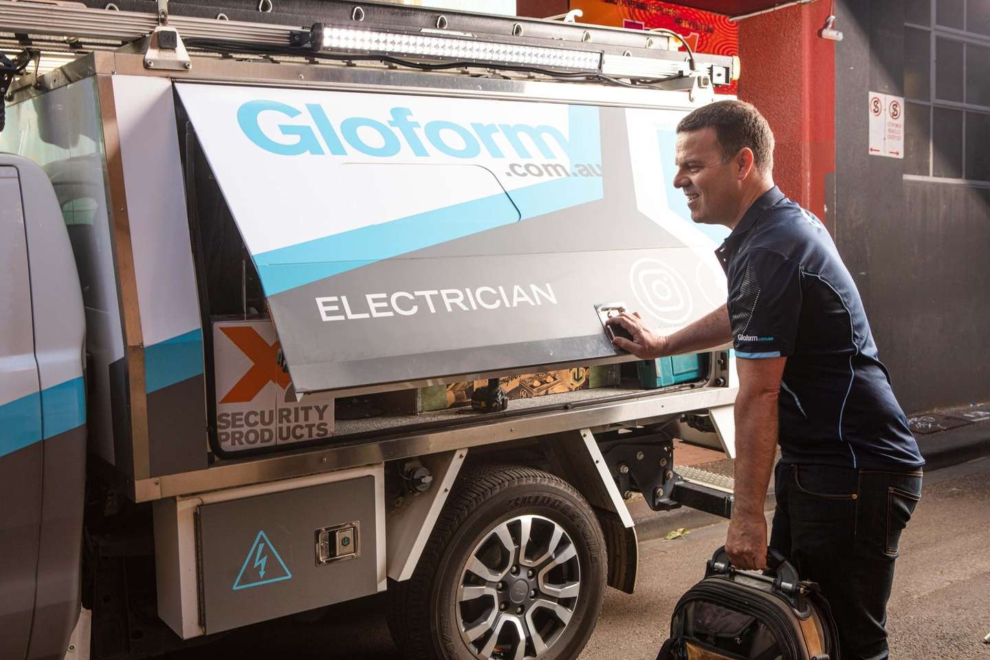Simon from Gloform Electrics opening the toolbox on the branded work ute